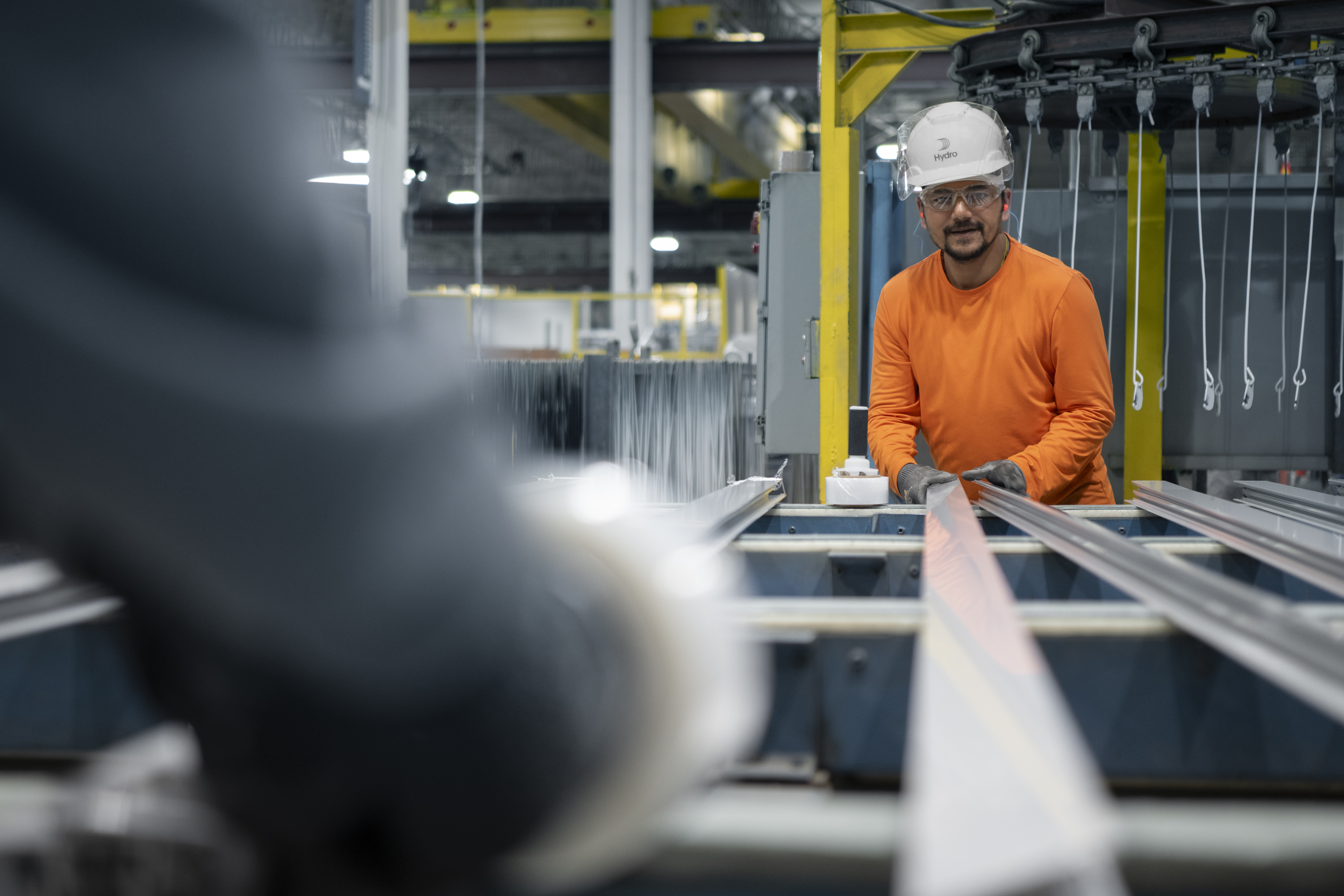 a man wearing a hard hat and orange shirt