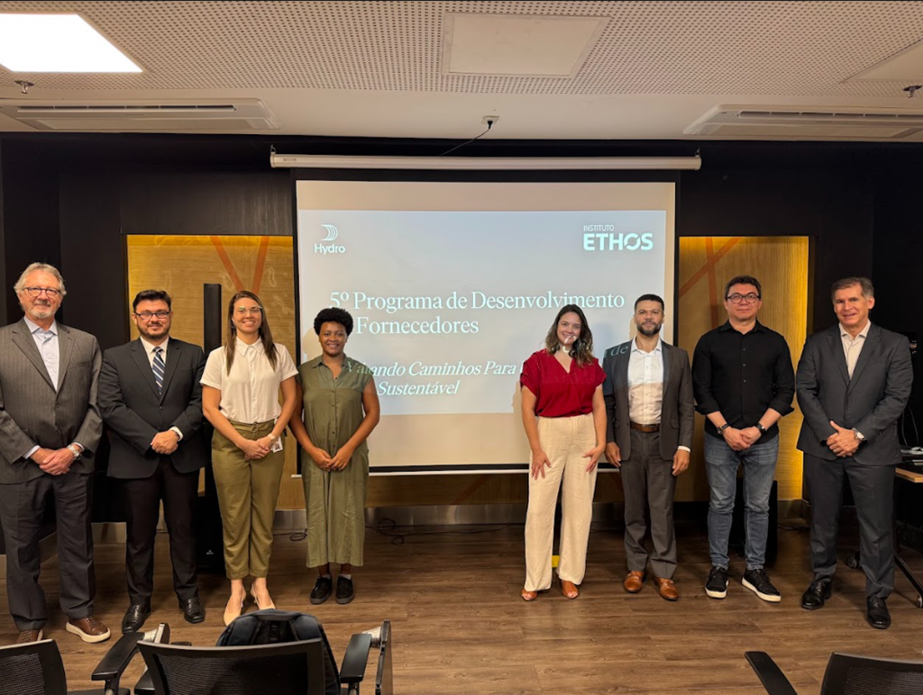 a group of people standing in front of a large screen