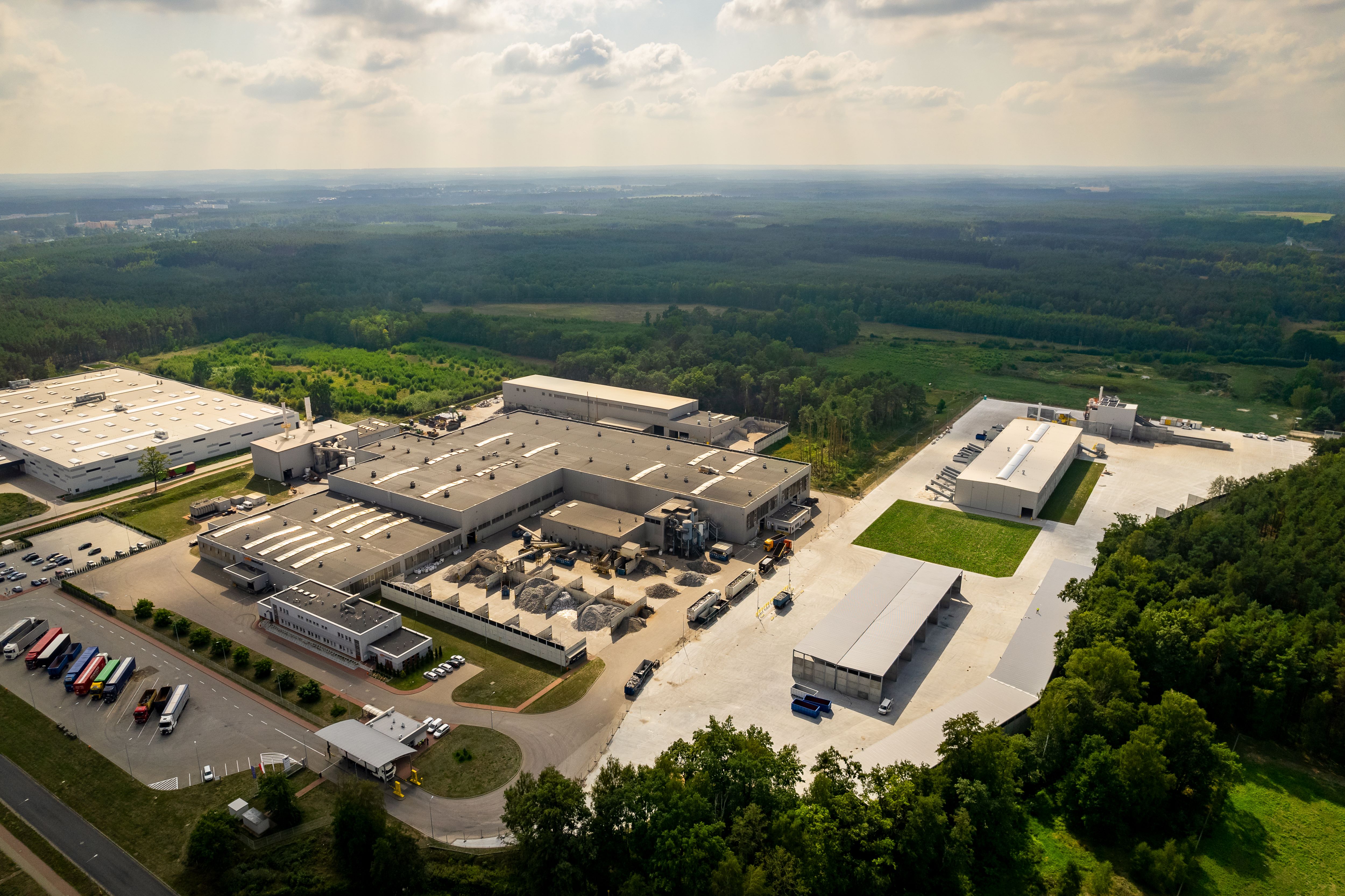 aerial view of a large factory with trees and a road