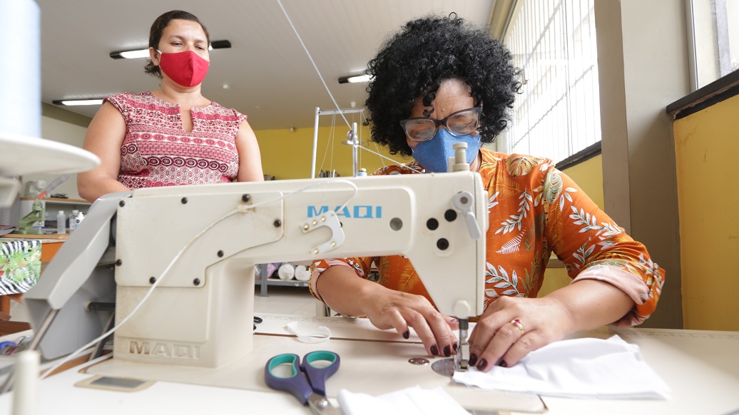 a woman and a man in a lab coat looking at a microscope