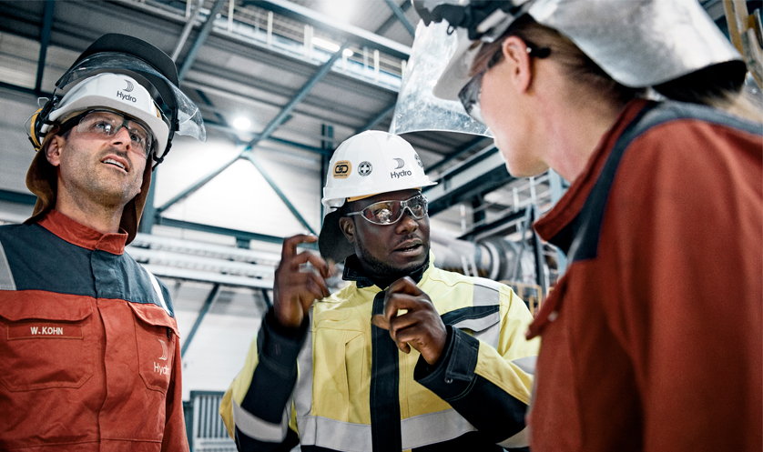 kleine Gruppe von Hydro-Mitarbeitern in Schutzkleidung