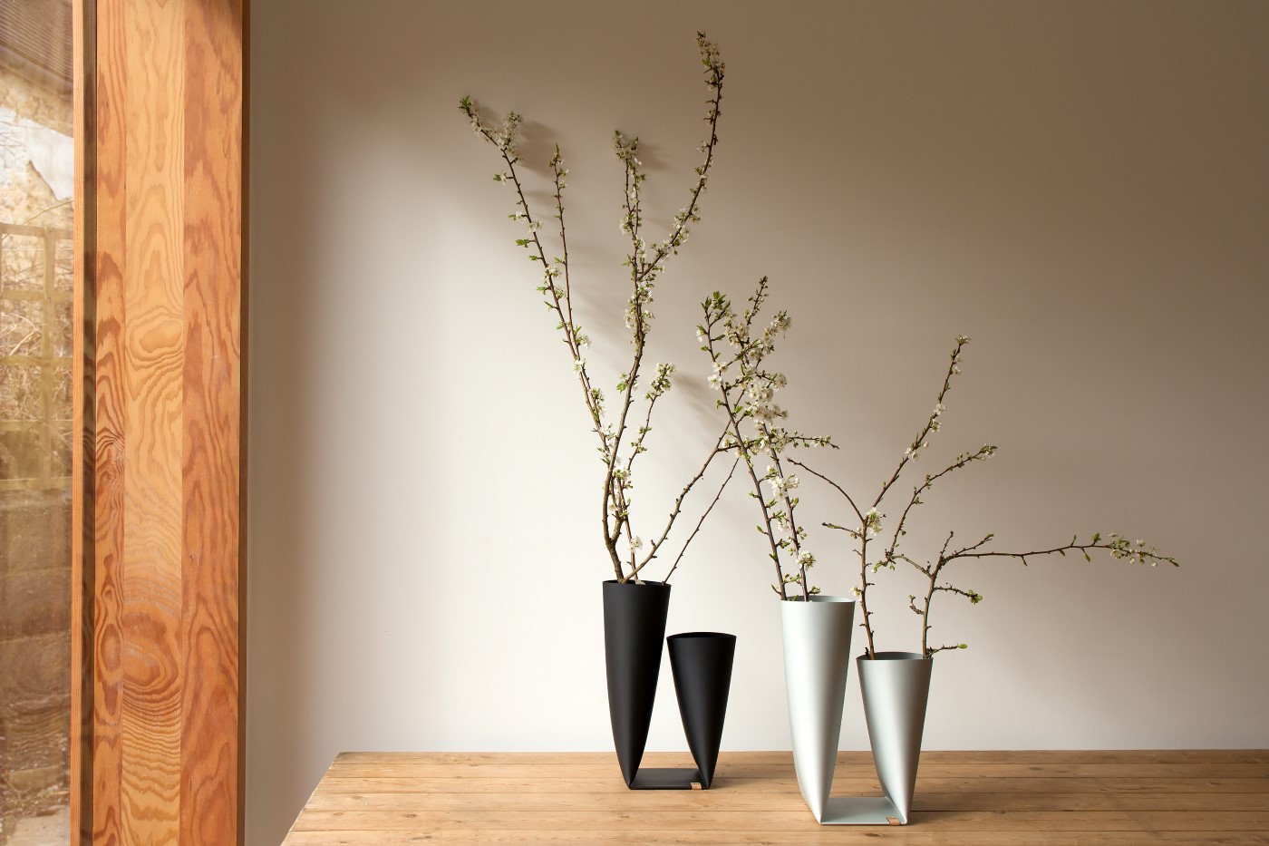schwarze und weiße Vasen aus Aluminium auf einem Tisch